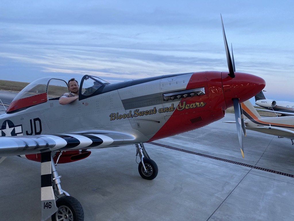 Andrew seated in a vintage aircraft on the ground