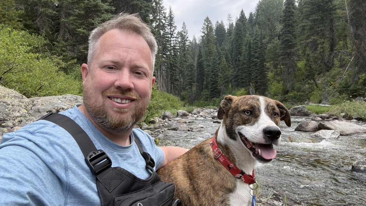 Andrew and his dog Chance beside a river